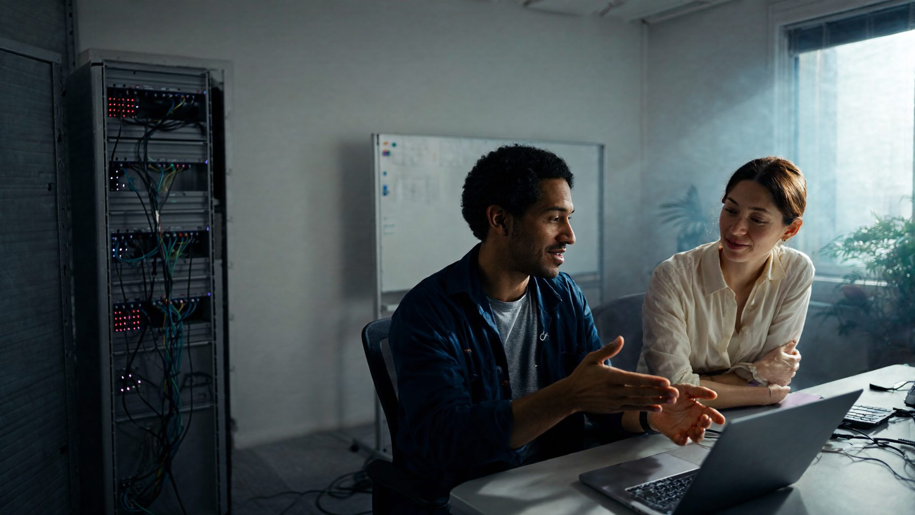 An IT consultant walking a business owner through a setup on a laptop